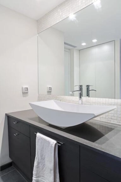 A modern bathroom featuring a large sink and a stylish mirror.