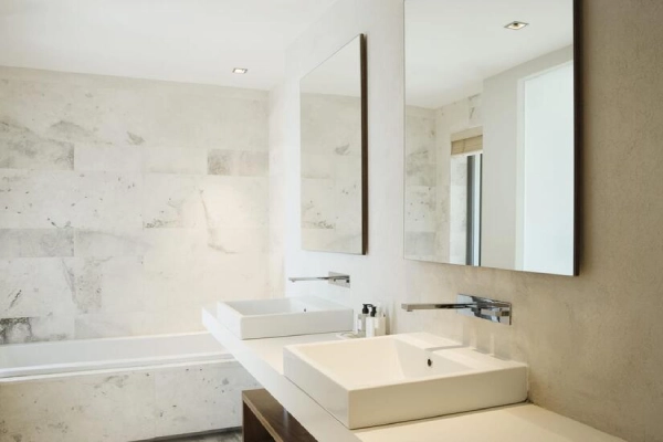 An elegant bathroom with dual sinks and a tub.