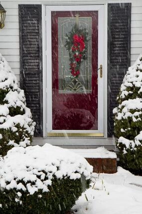 A red door surrounded by snow