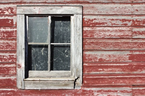 An old window framed by the vibrant red colour.