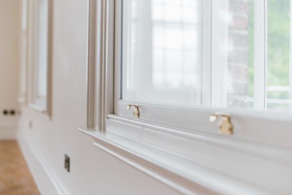 Close-up of a gold sash lock on a white window