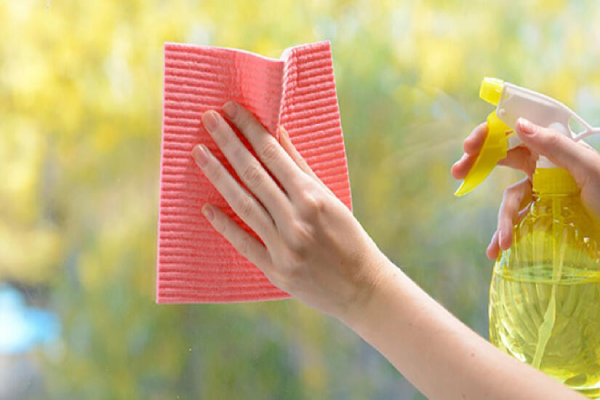 A person cleans a window with a rag.
