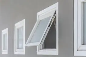 a close-up of a awning window open outward with a top hinge