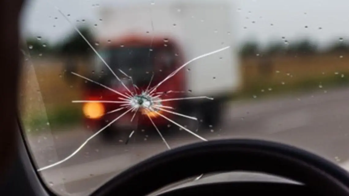 a close-up of a car’s windshield with several cracks