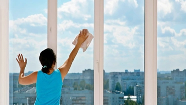 A lady cleaning glass surface.