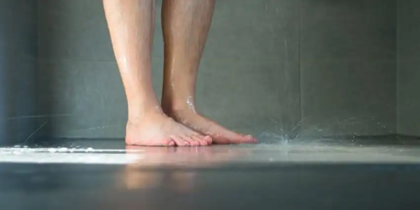 The floor of a shower while a person is showering.