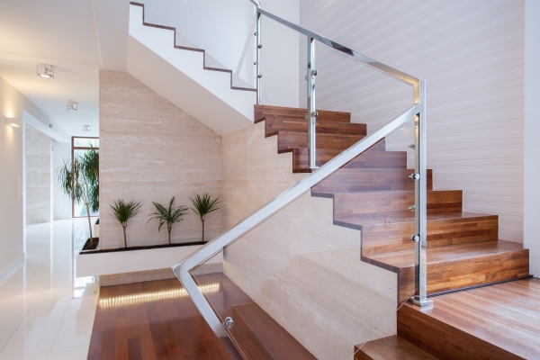 Glass staircase railing in residential home with wood staircase.