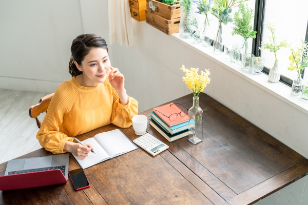 Young woman sitting and working at a desk in her home office